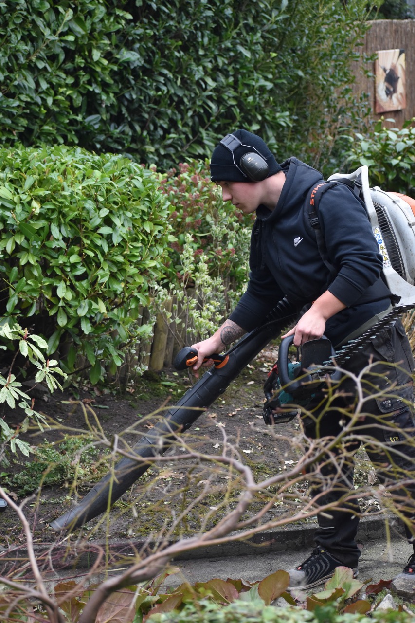 Een Groenmaat-hovenier verzorgt de beplanting in een tuin